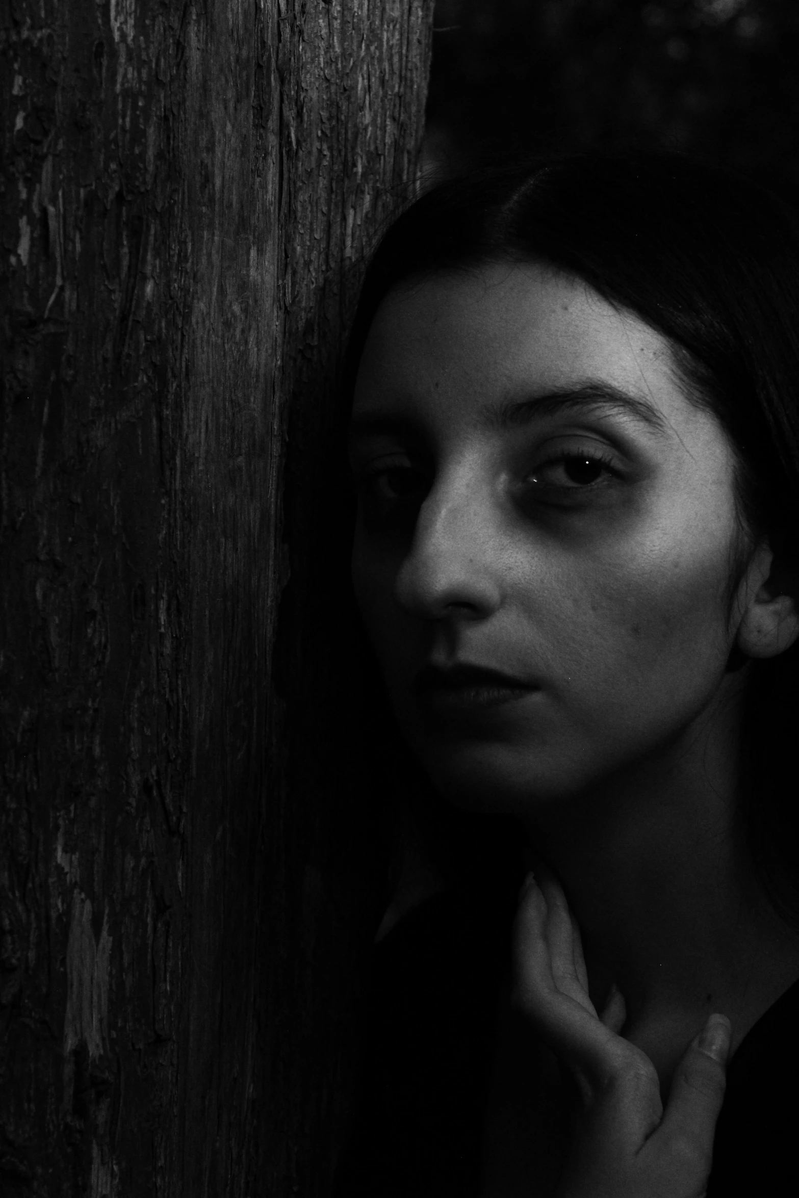 a woman is leaning on the wooden wall