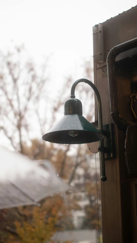 a lamp on the side of the house next to an open window