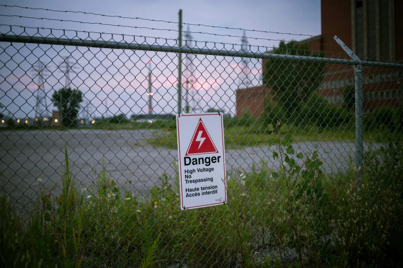 a sign next to the road near the fence