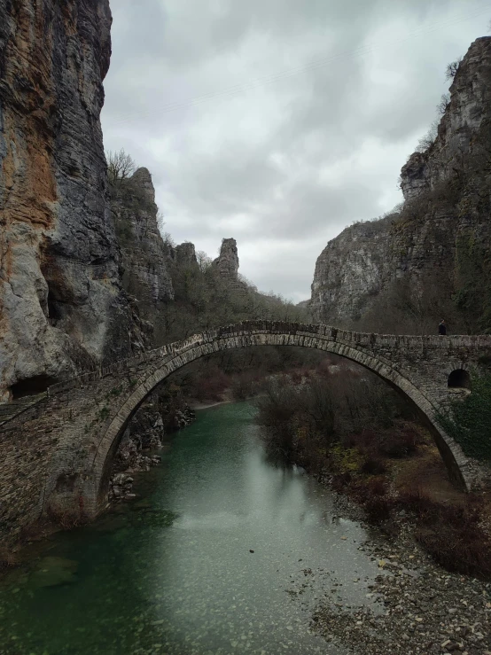 a bridge over a lake surrounded by rocks