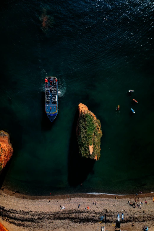 the ocean with boats, rocks and beach chairs