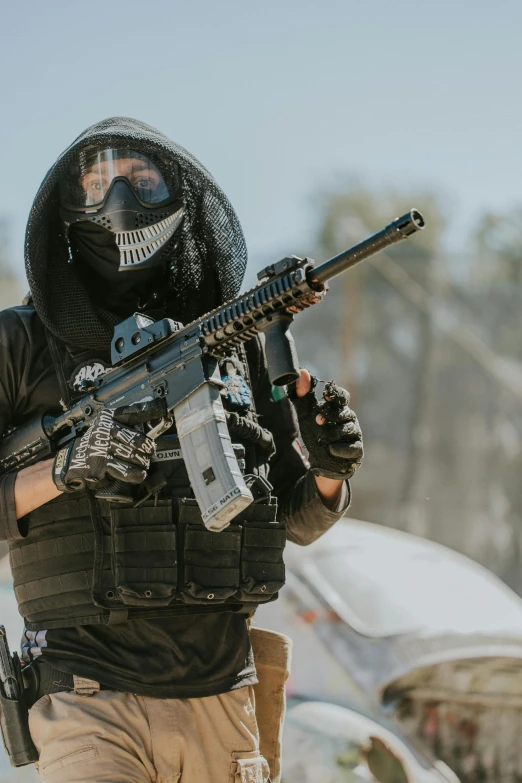 a person with a mask and holding a machine gun