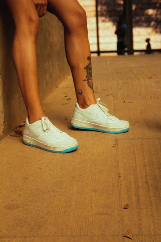 a person's feet resting against the wall near water