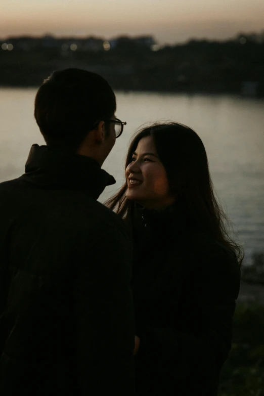 man and woman next to a body of water