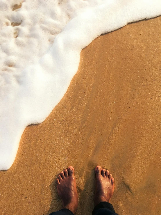 two people that are laying down on a beach