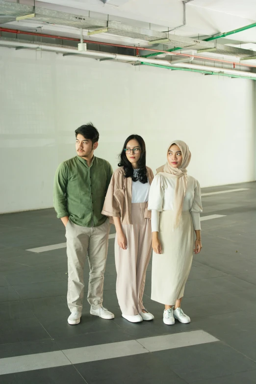 three people posing for a picture in an empty room