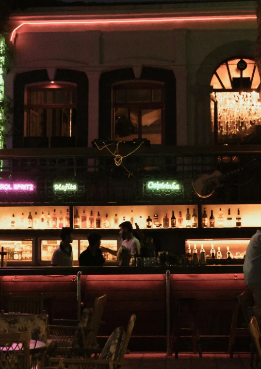 people sitting at a bar on a dark night