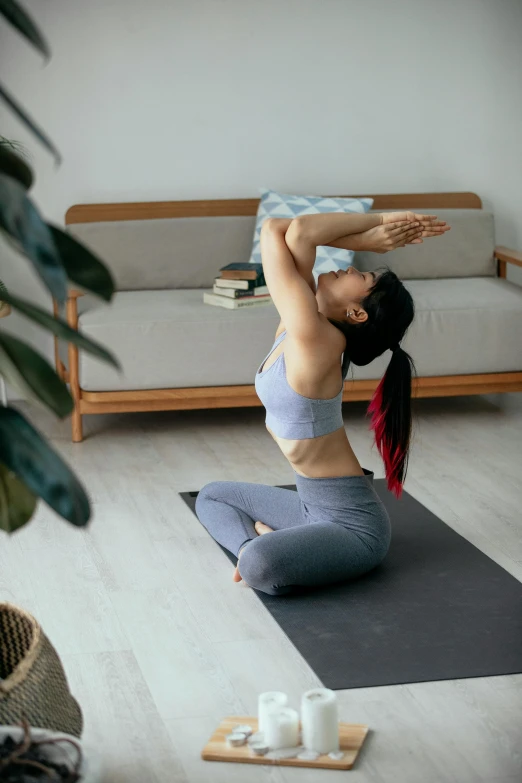 a woman in a black  and blue pants doing yoga