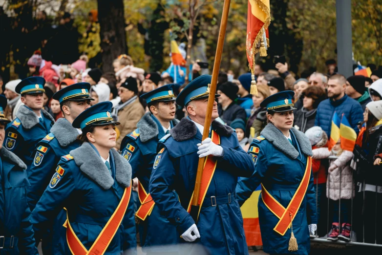 people in blue coats marching during a parade