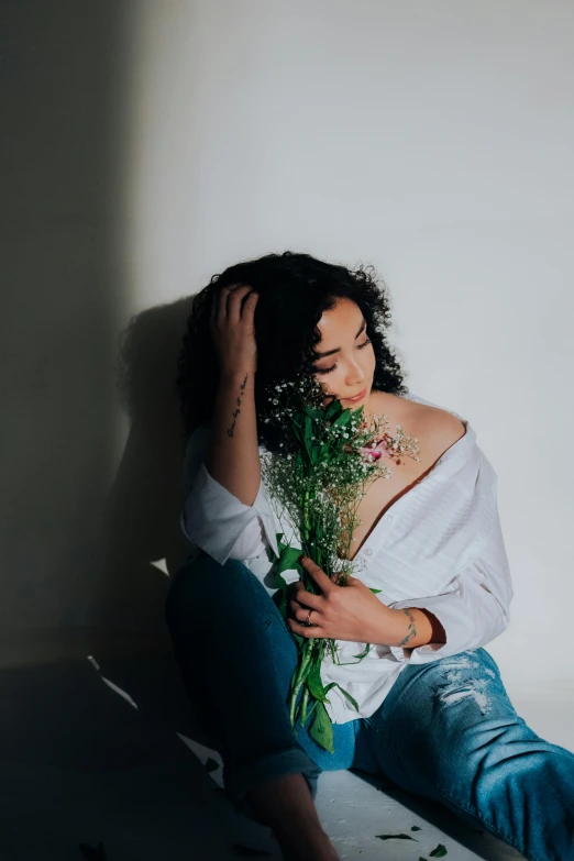 a woman holding flowers sitting on the ground