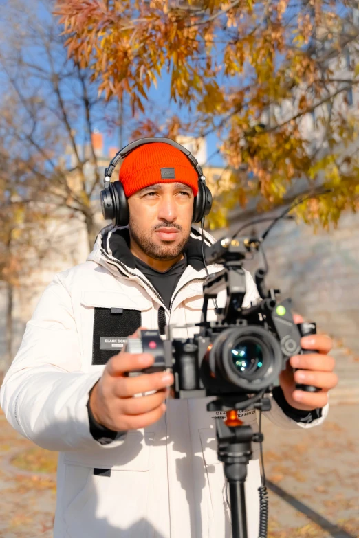 a man on a camera in front of a tree