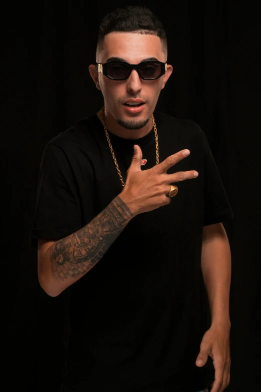 a man with a tattoo and sunglasses showing off his finger