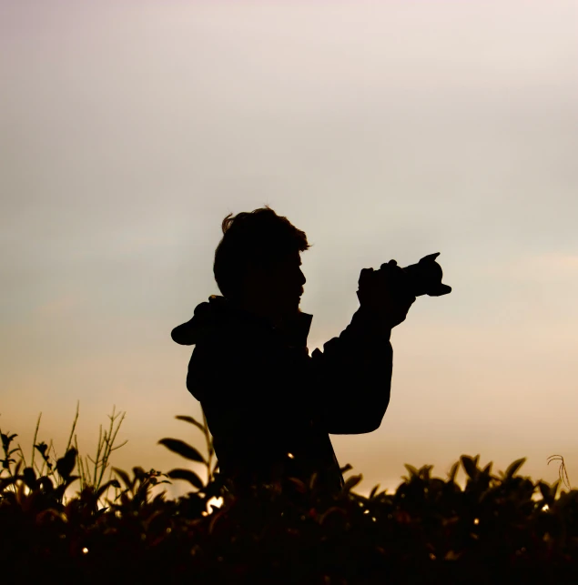 a silhouette of a man holding up his hand