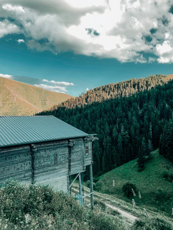 an old, wooden building on the side of a hill