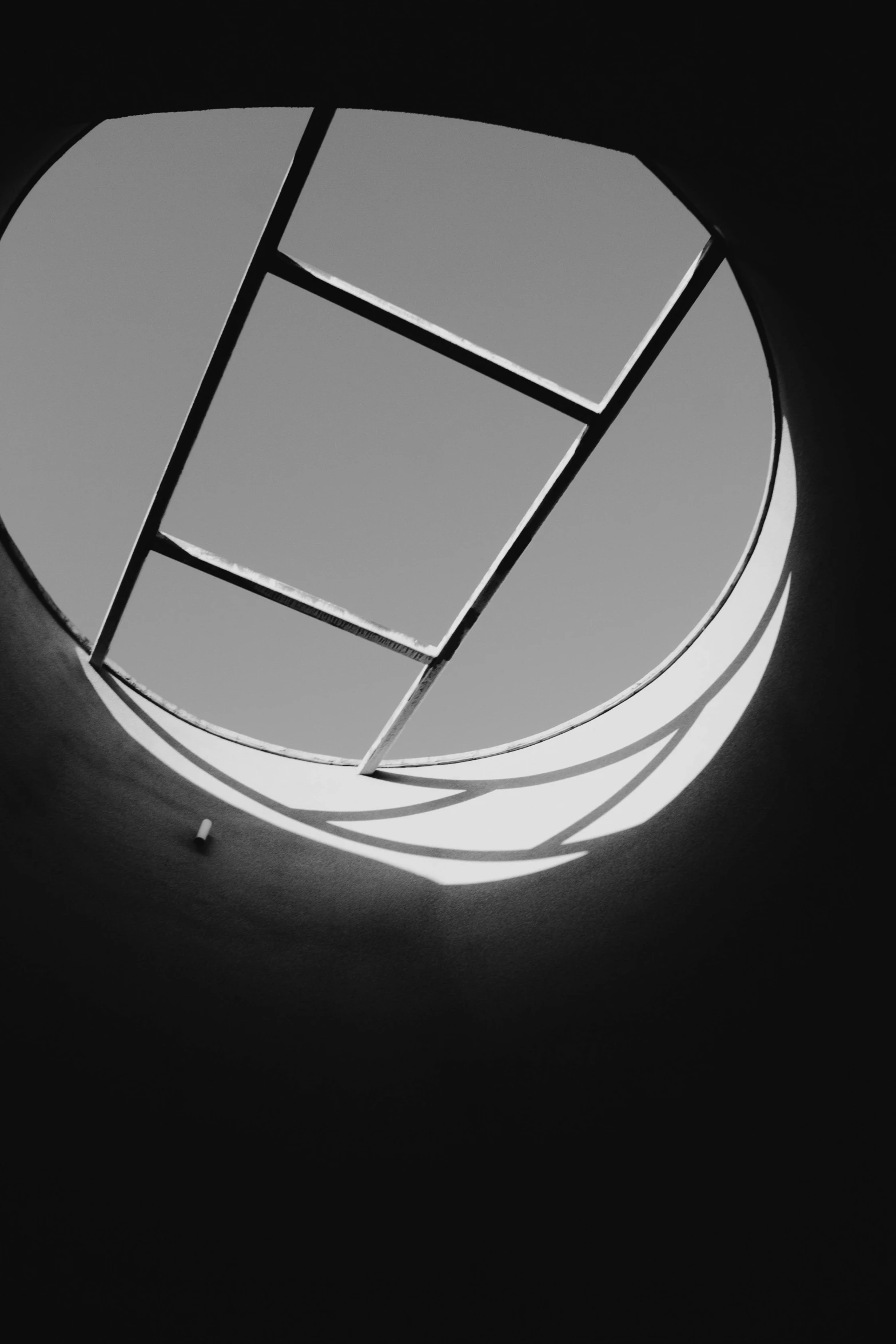 looking up at the circular mirror in the center of a circular window