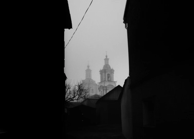a dark street next to a large church tower