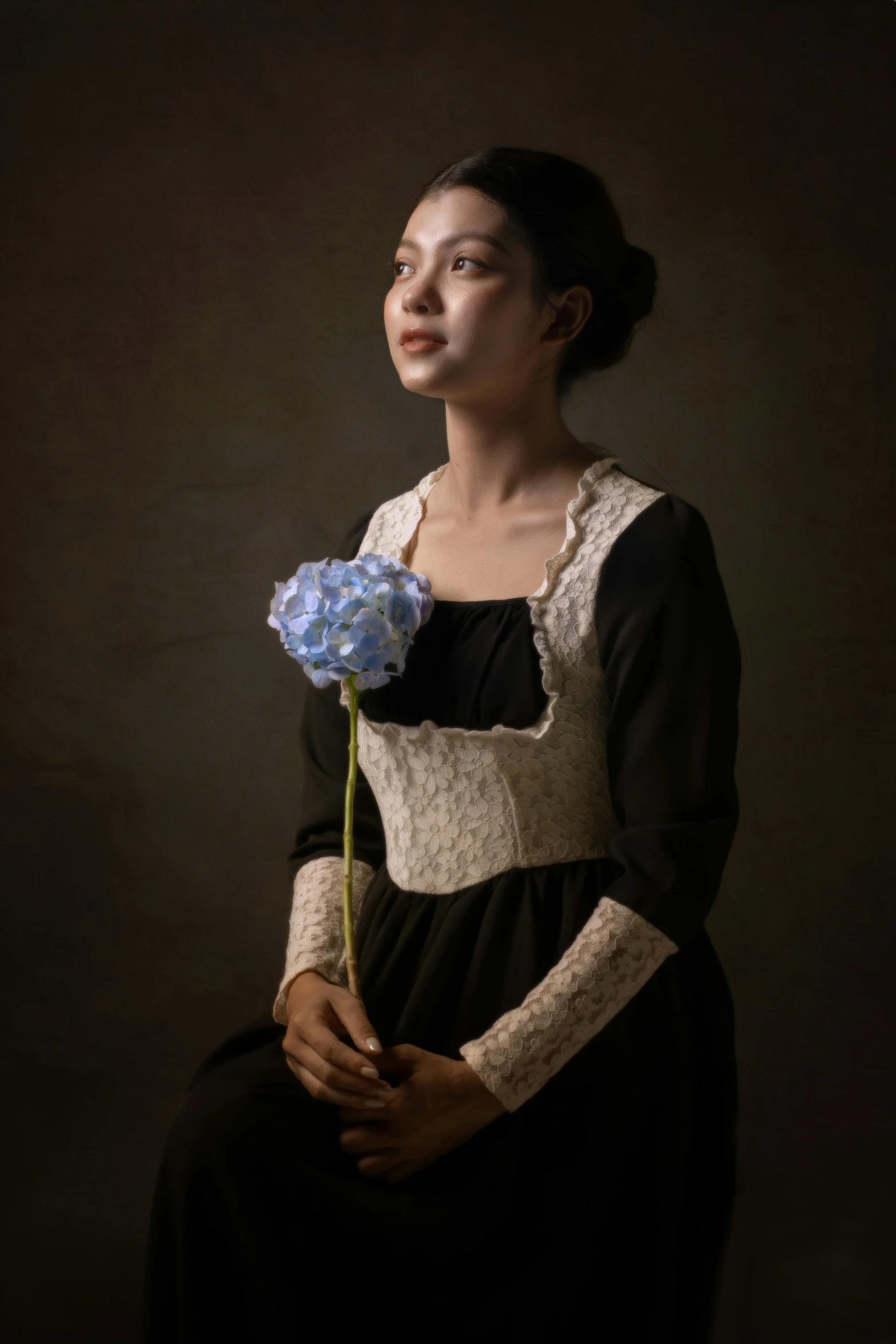 a beautiful woman in a long dress holding a blue rose