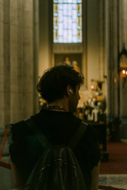 a woman wearing earrings while standing in front of a church