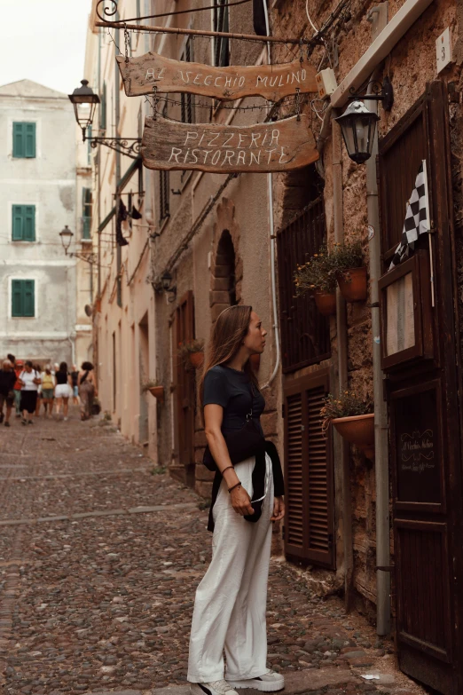 a woman standing in the middle of a narrow street