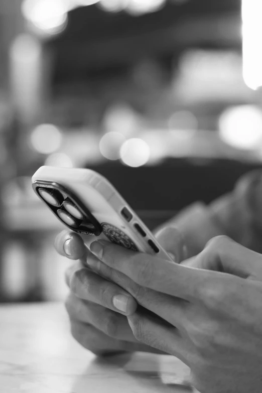 someone is typing on their cell phone at a table