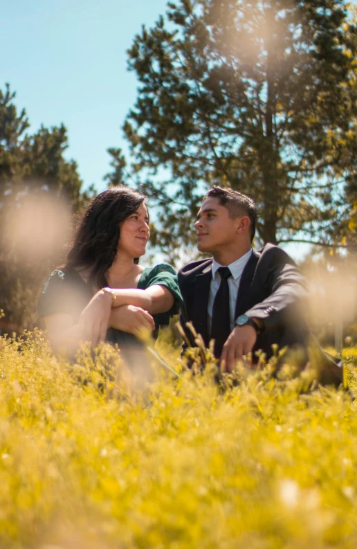 the couple is posing for a portrait in a field