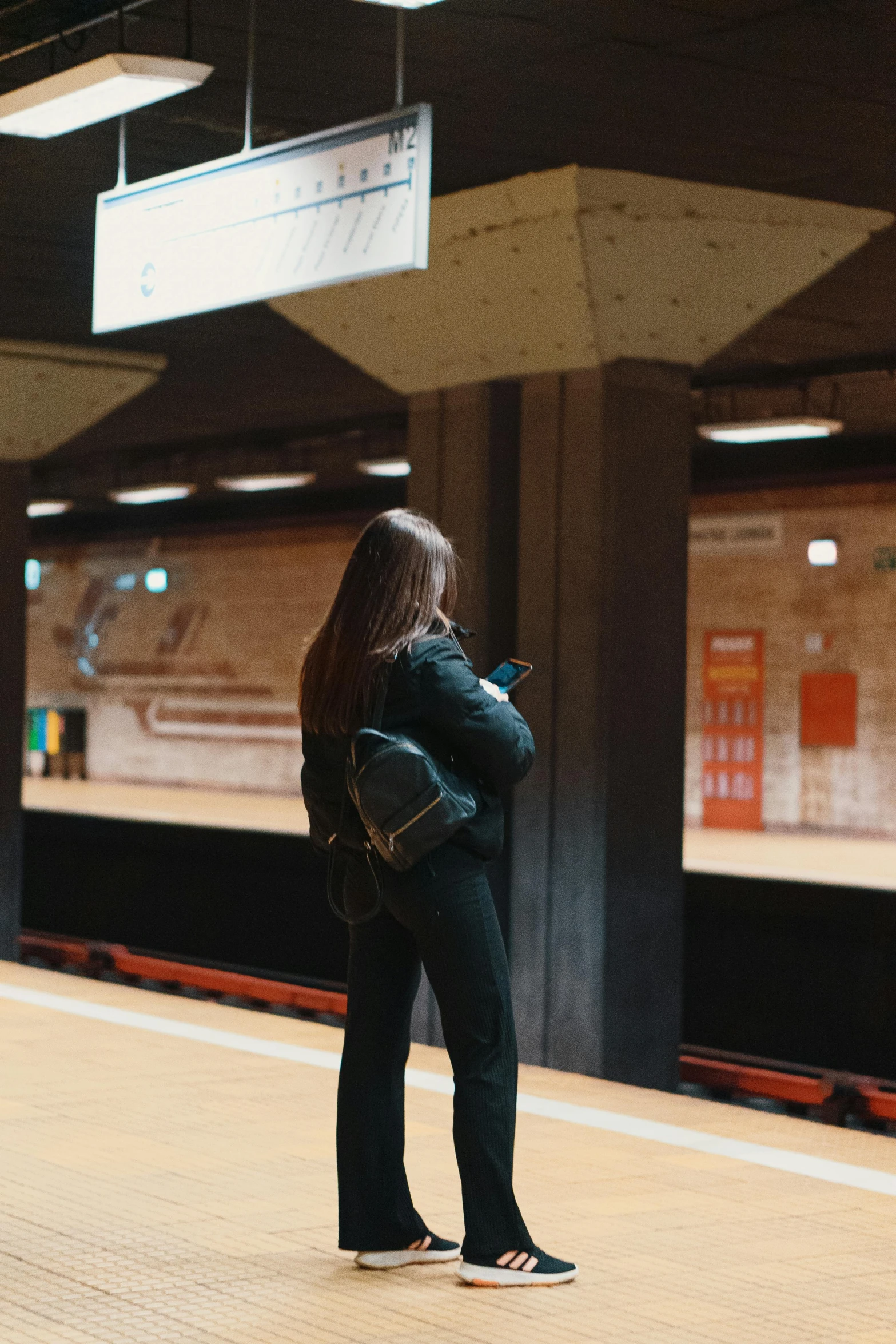 woman waiting on the subway platform for her train