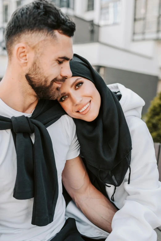 an engaged couple wearing black scarfs and scarves