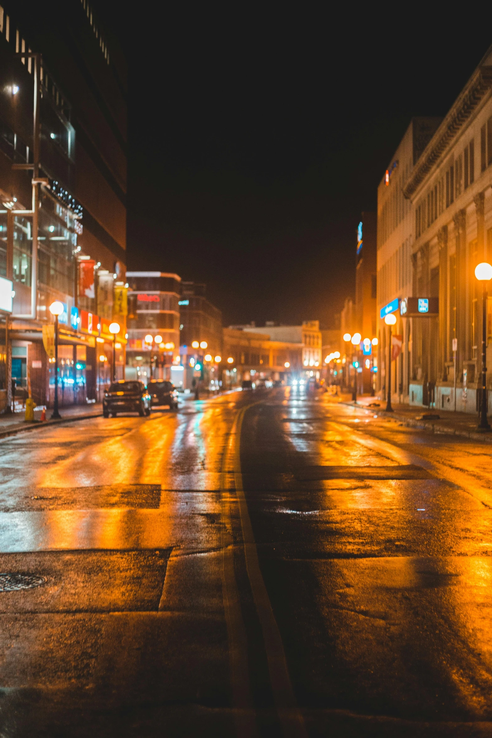 people are sitting on the sidewalk on a rainy night