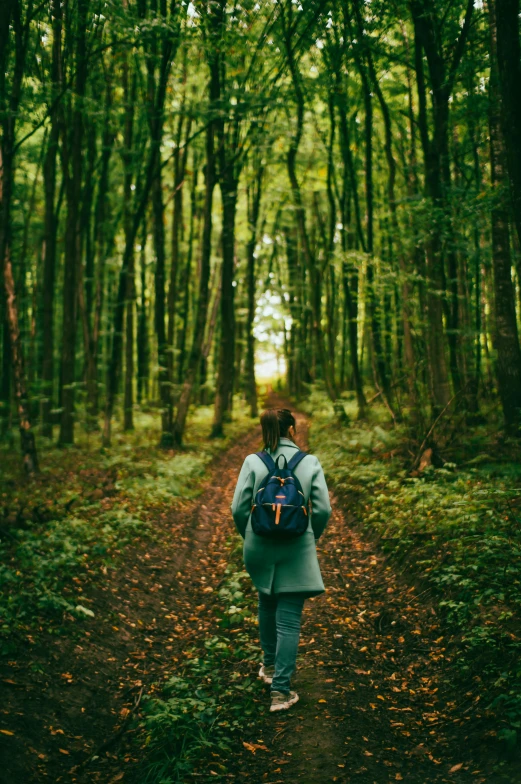 there is a woman in the woods with a backpack