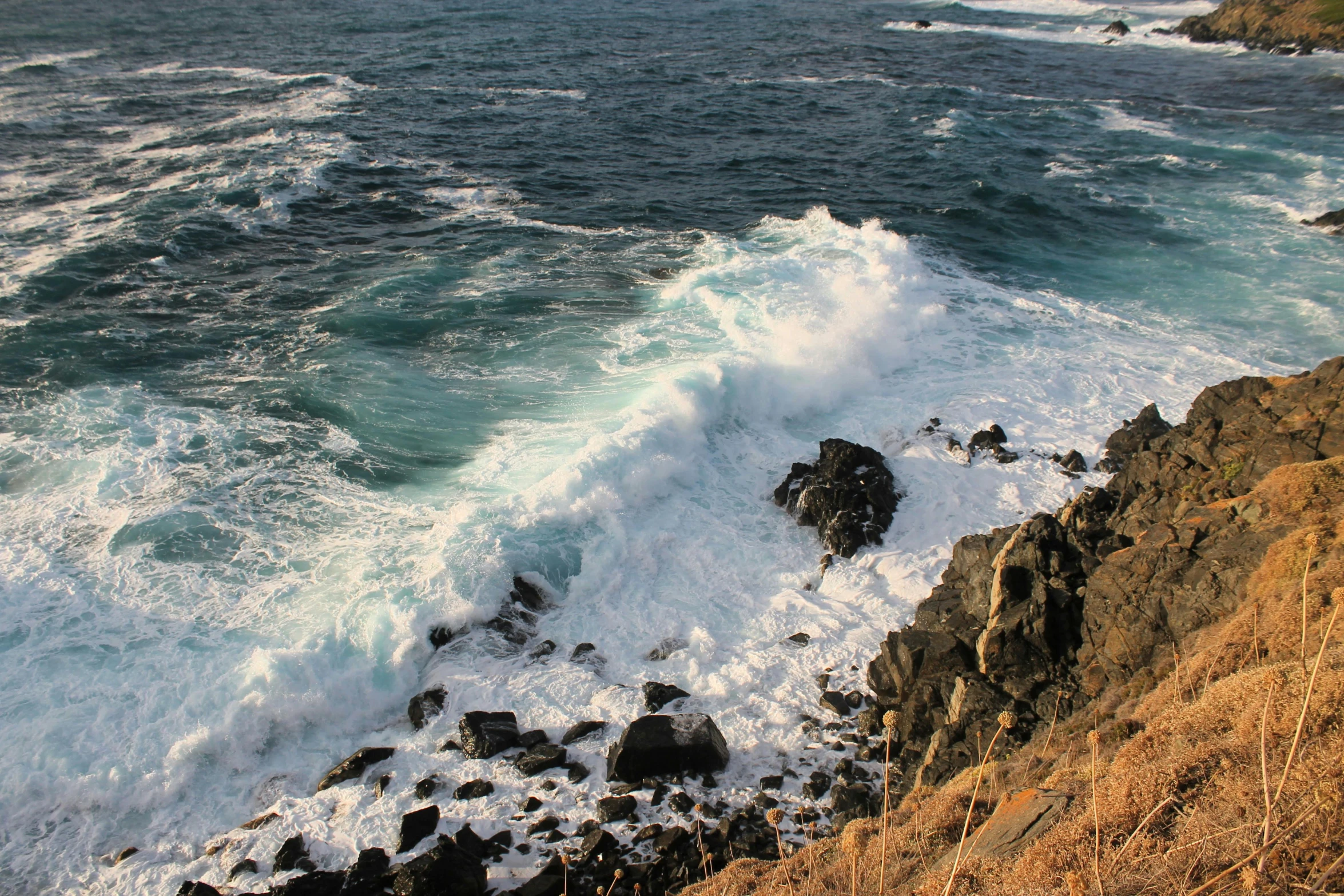 a group of rocks that are next to the ocean