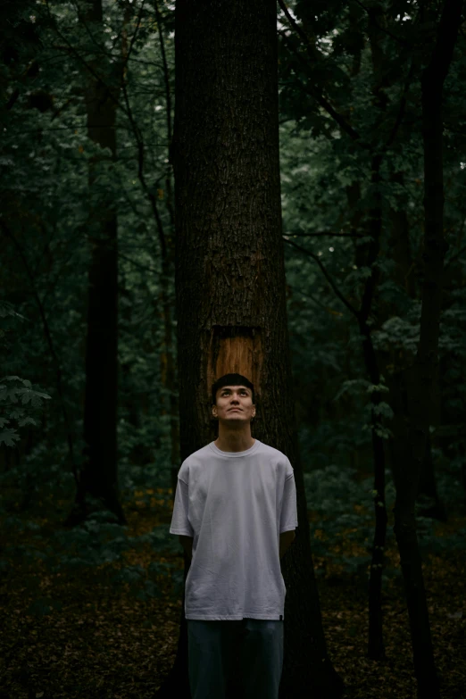 a person standing by a tree with their eyes closed