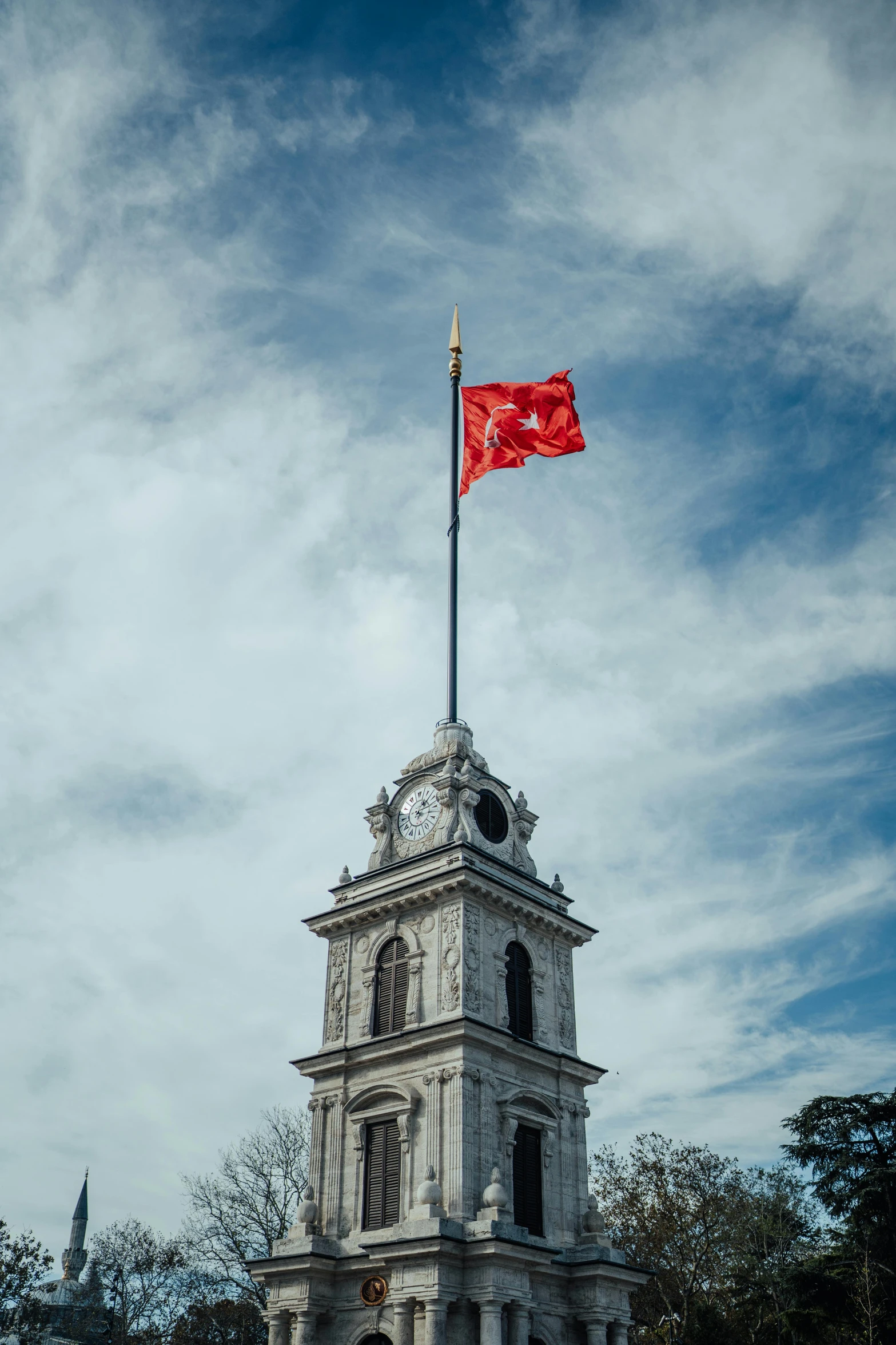 a large red chinese flag sitting on top of a tower