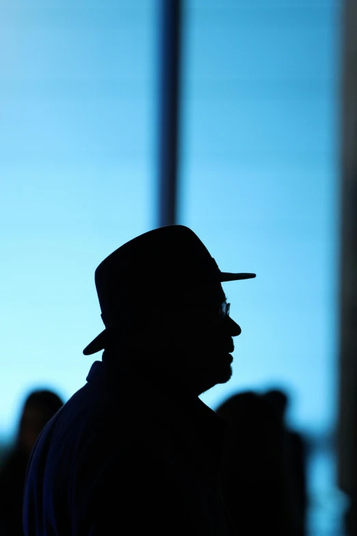 the silhouette of a man in a hat