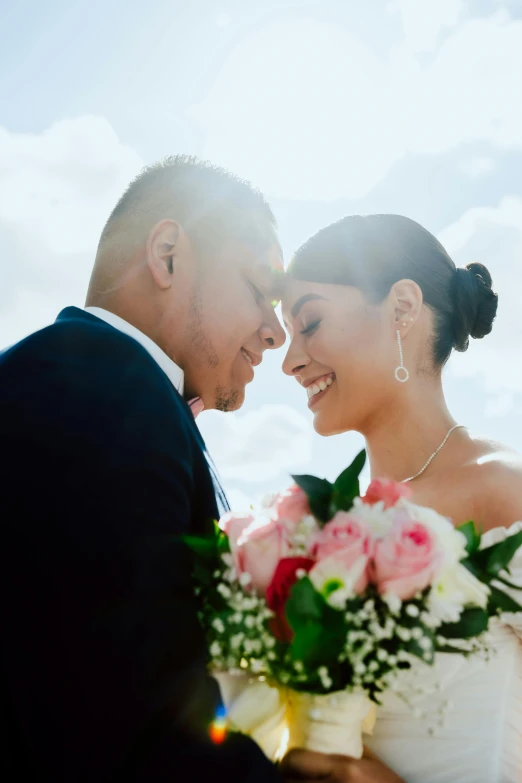 bride and groom standing close together on the beach