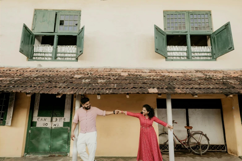 couple standing in front of a house and holding hands