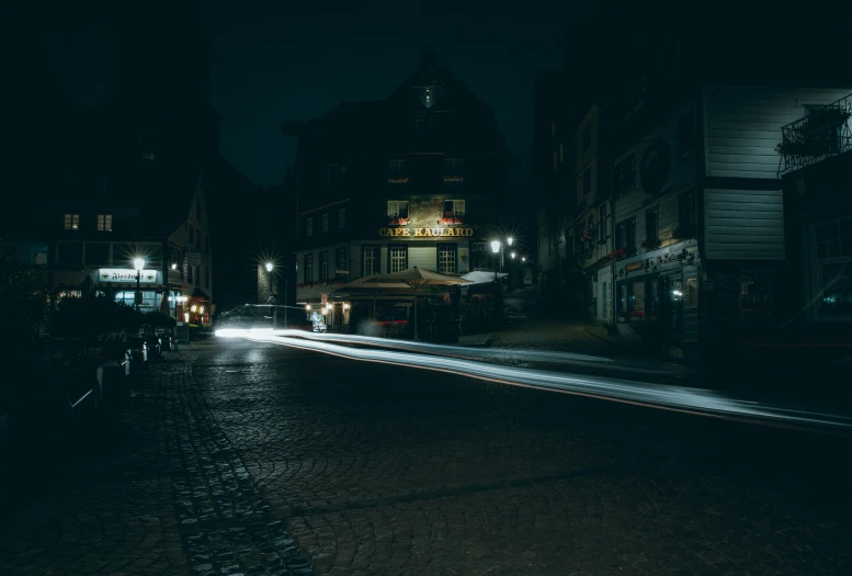 a street scene with cars going by at night