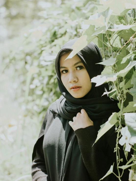 young woman in black in a grove of leaves