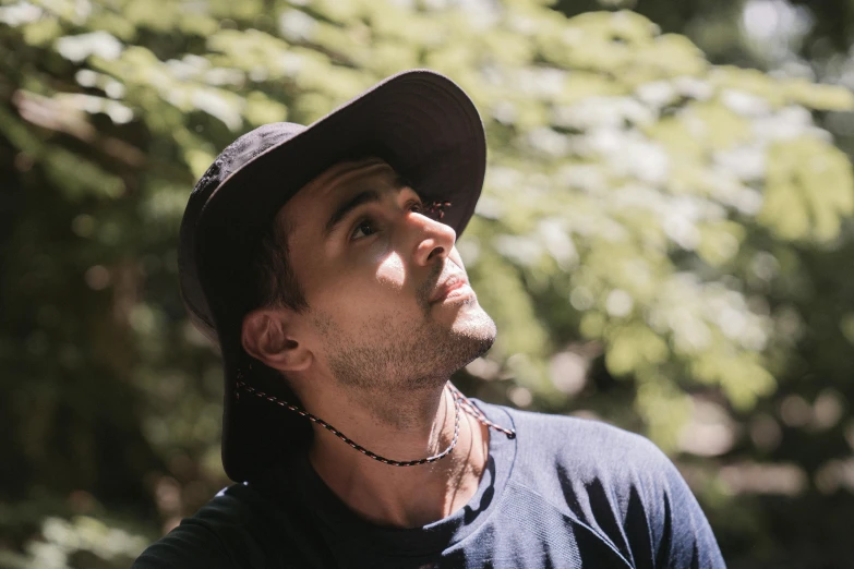 a man with his eyes closed wearing a black hat