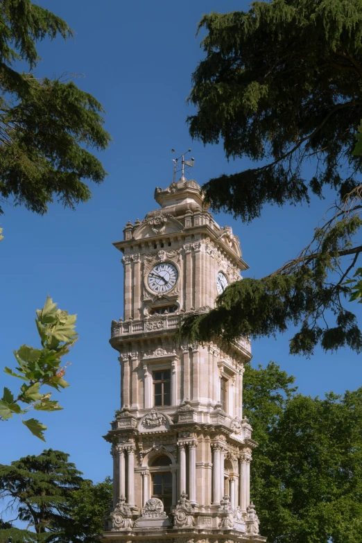 a large clock tower sitting next to a tree