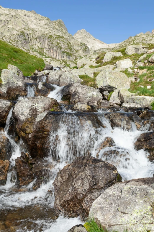 a man is standing on a rock by a water fall