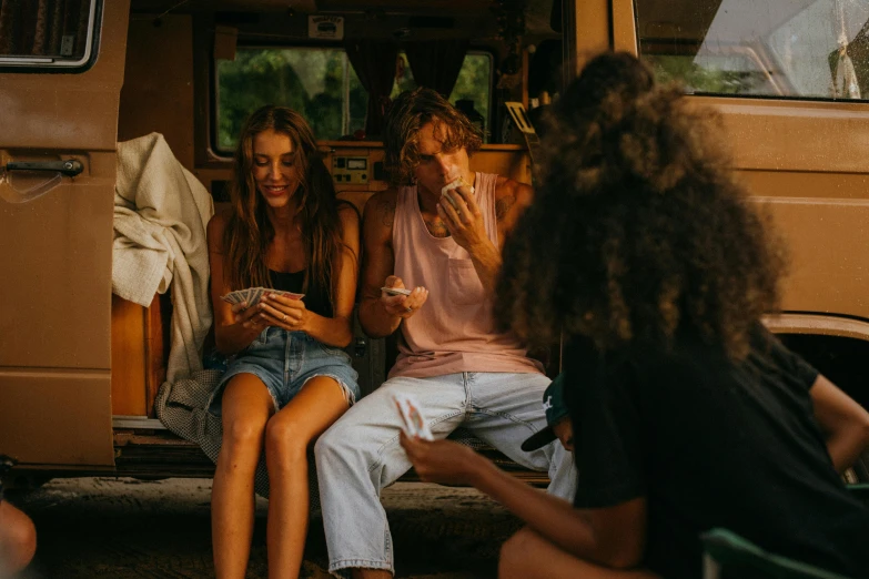 some very cute girls sitting by a van