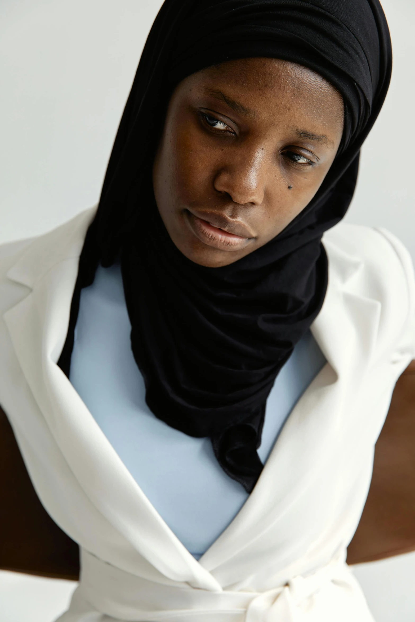 a black woman wearing a scarf, a top with a bow