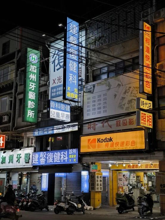 neon signs of various countries lit up by lanterns on the streets of hong kong