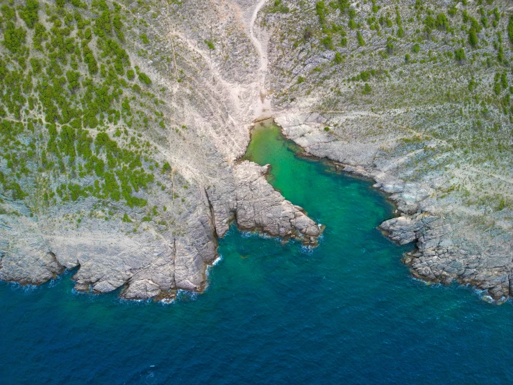 an aerial s of green water and rocks