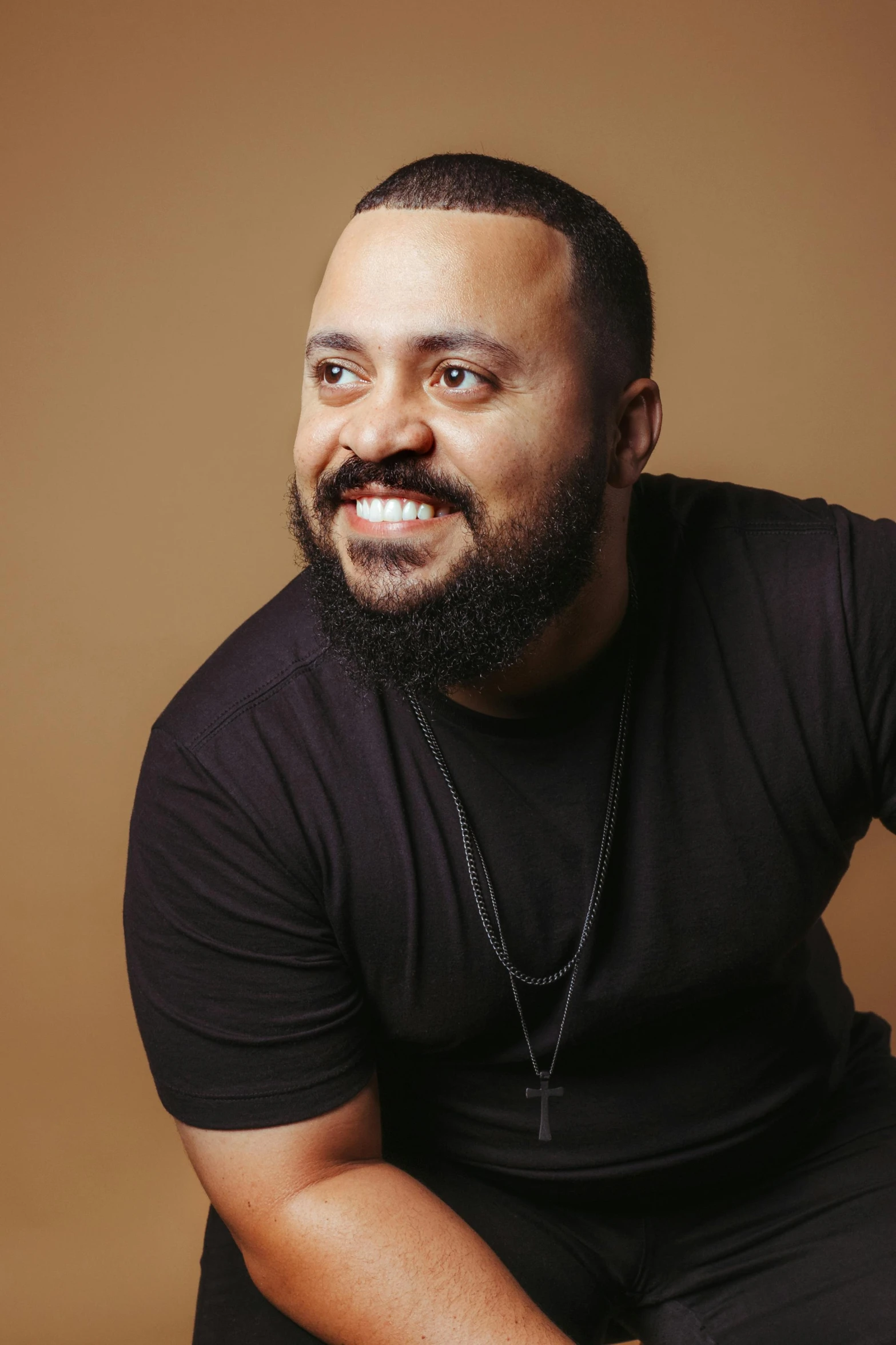 a man posing in front of a brown background