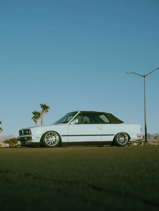 an old white car parked on the side of the road