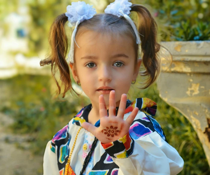 a girl holds her hand up in front of her face