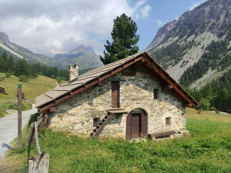 a building made out of stone sits in a grass field