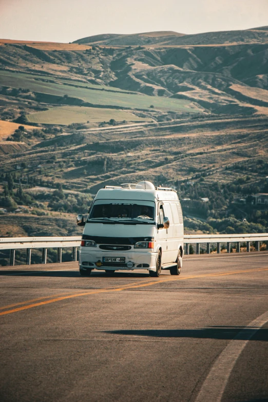 the back end of a white van moving along a highway