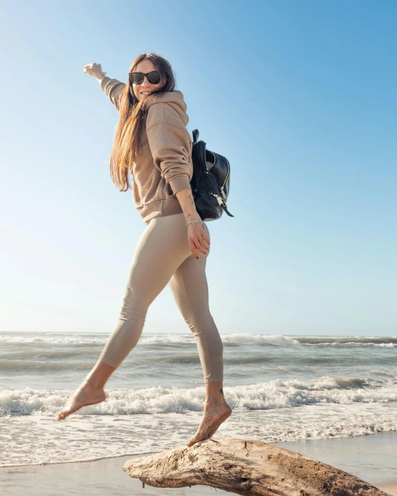 a woman is on the beach jumping